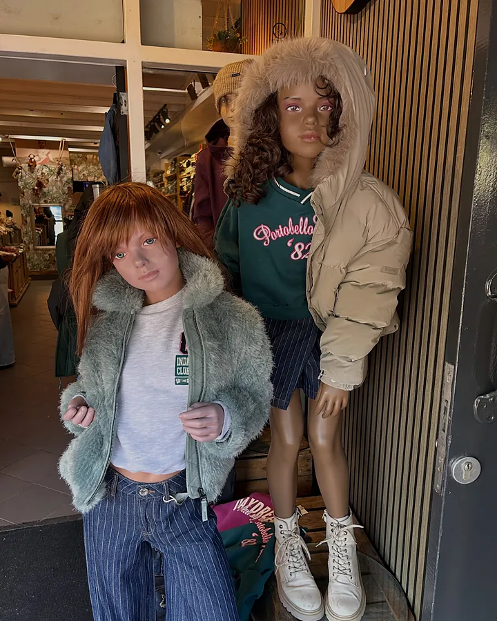 Twee poppen bij de deur in een teddyjas en een gewatteerde jas