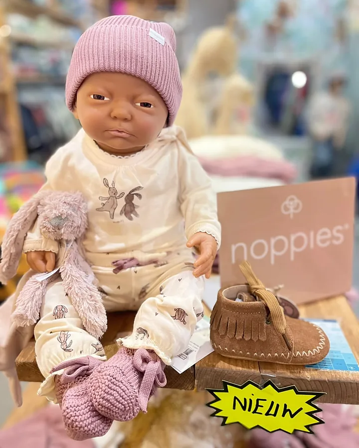 Babypop in een Noppies setje met mutsje
