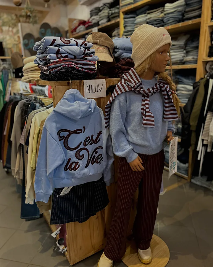 Lichtblauwe hoodie en trui met gestreepte sjaal op een pop