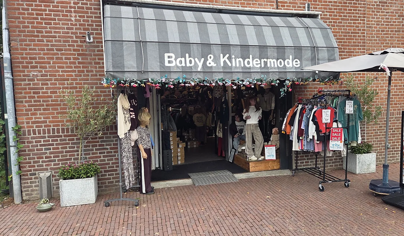 De winkel aan de Turfkade met de grijs-wit gestreepte luifel en het rek buiten